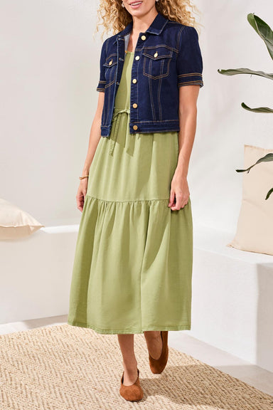 Woman wearing a sage green midi dress with a denim jacket